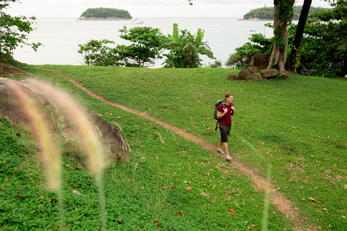 Man walks along path past tropical foliage
