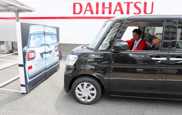 Yorie Miho tries out the automatic emergency braking system in a Daihatsu minicar at a minicar dealership in Yamato