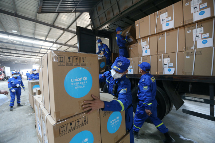 Volunteers carry down UNICEF donated supplies in an emergency wa