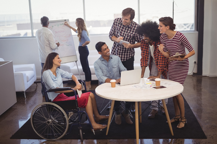 Business people discussing strategies with disabled colleagues