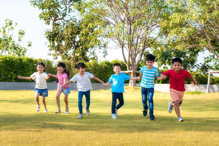 Large group of happy Asian smiling kindergarten kids friends hol