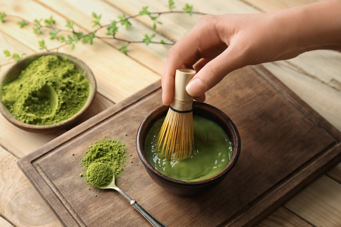 Woman preparing matcha tea, closeup