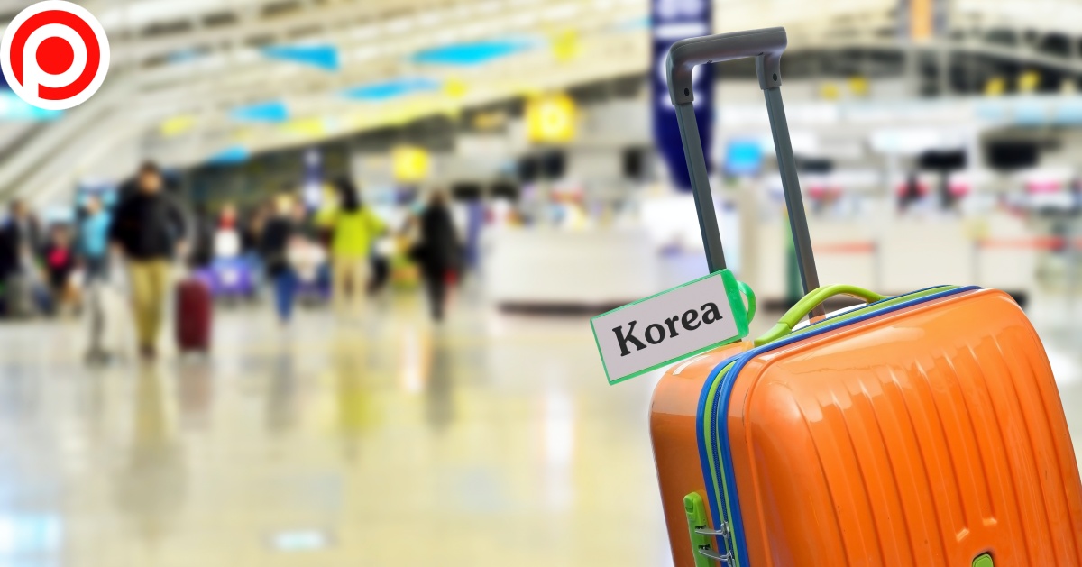 Korea.,Orange,Suitcase,With,Label,At,Airport.