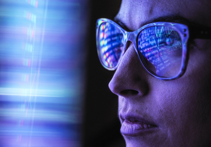 Female analyst viewing financial market data on a screen