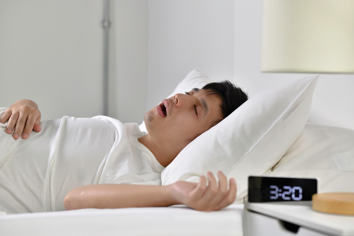 Young,Asian,Man,Sleeping,And,Snoring,Loudly,Lying,In,The