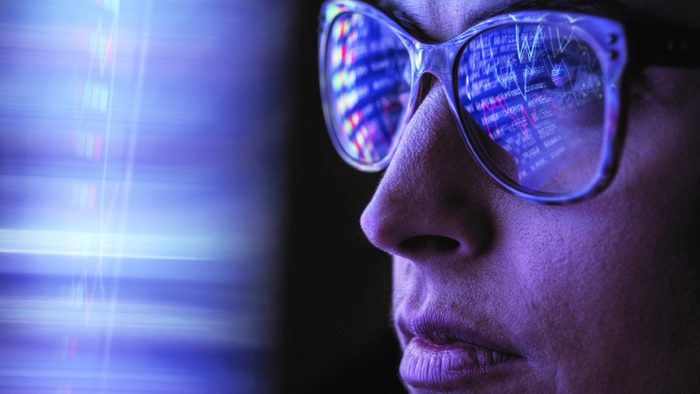 Female analyst viewing financial market data on a screen