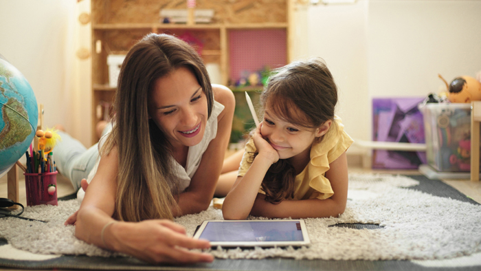 Mother and daughter using tablet computer and drawing with digitized pen at home