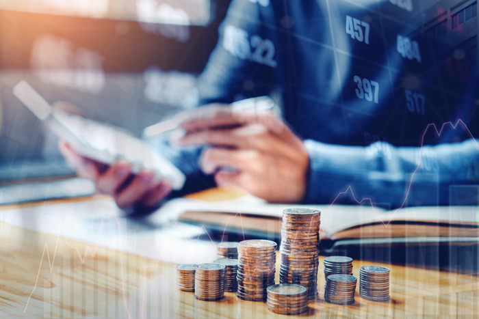 Graph on rows of coins for finance and banking on digital stock market financial exchange and Trading graph Double exposure city on the background