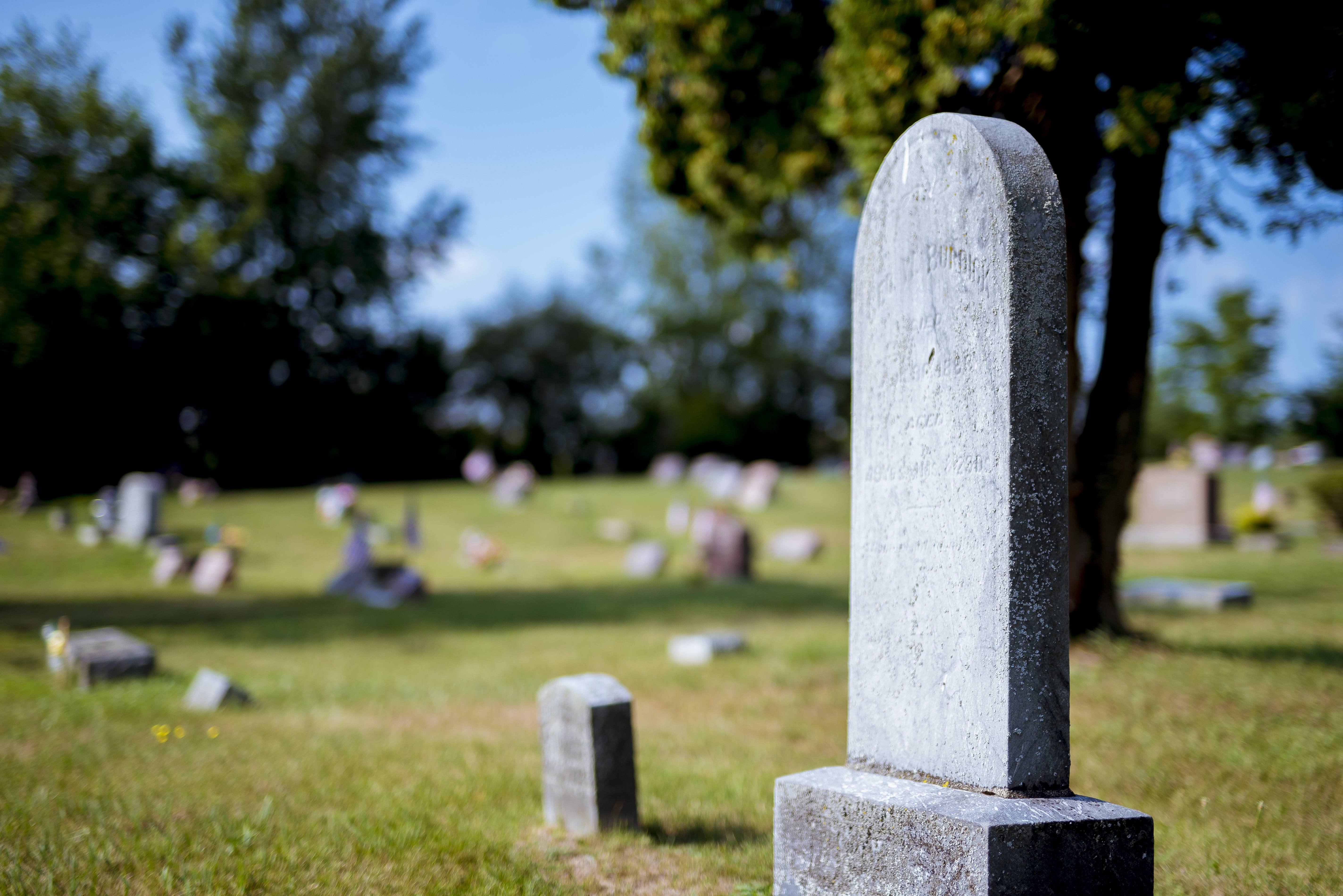 closeup-shot-gravestone-with-blurred-background-daytime.jpg