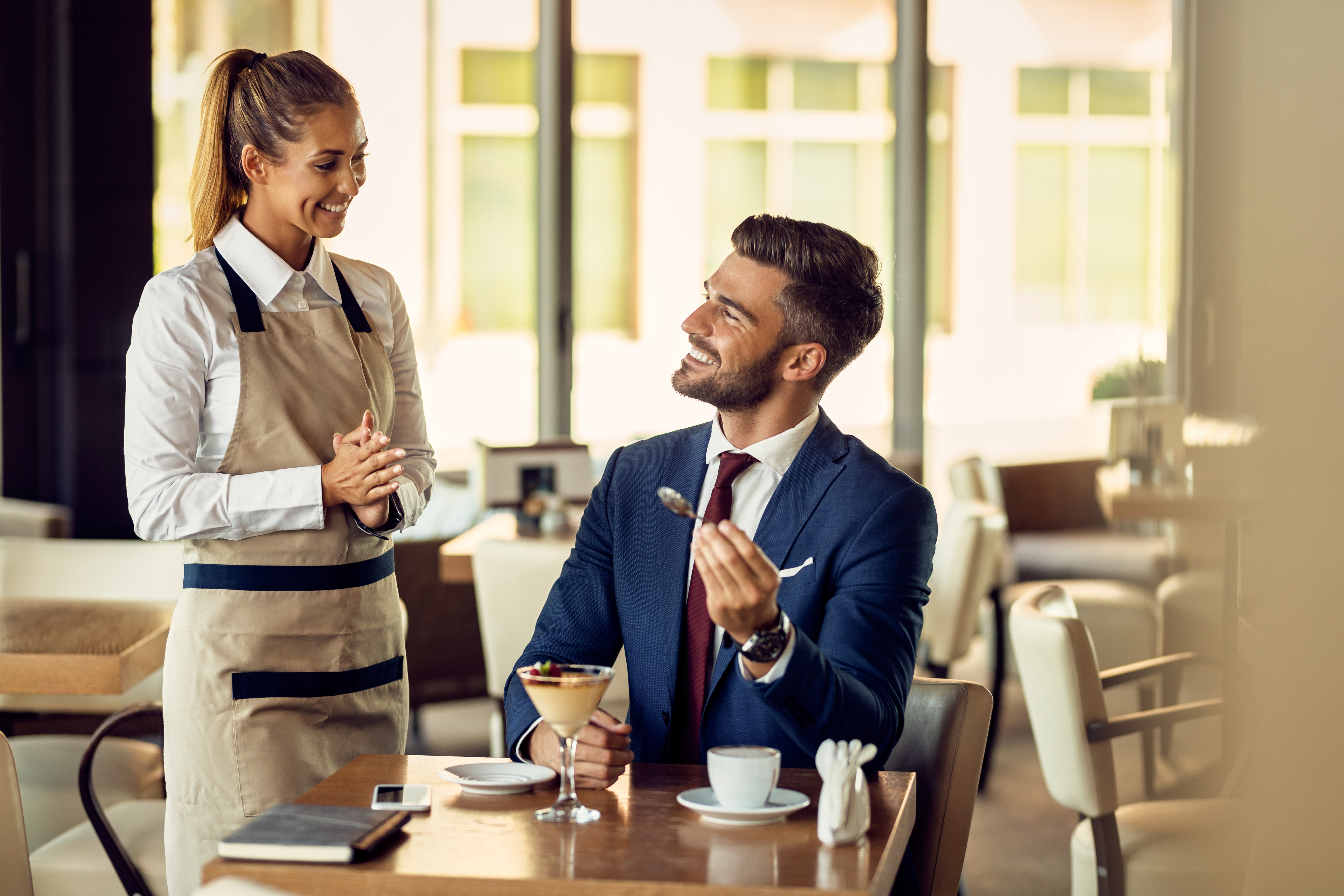 young-happy-waitress-talking-businessman-cafe.jpg