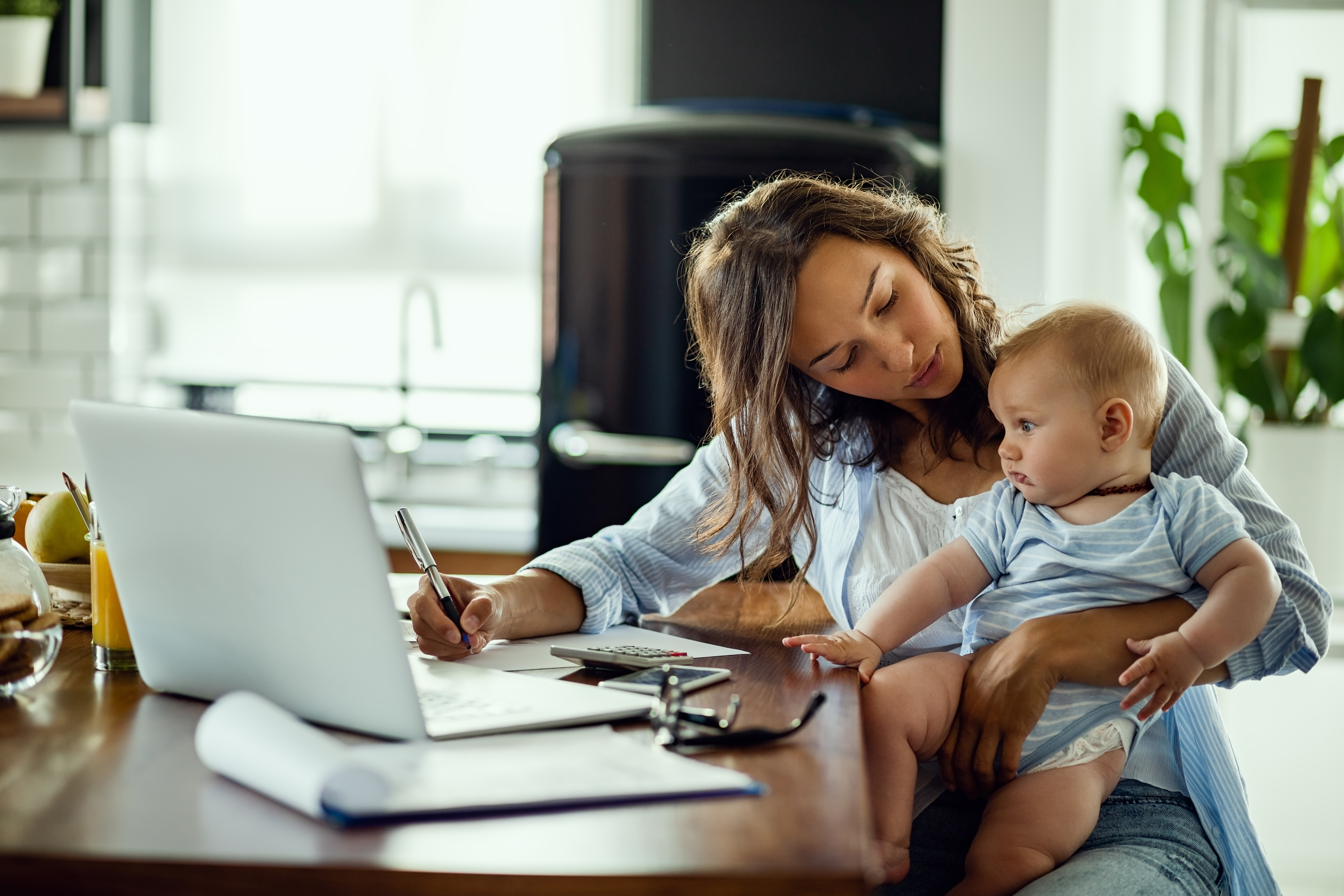 young-working-mother-planning-home-budget-while-being-with-her-baby-home.jpg